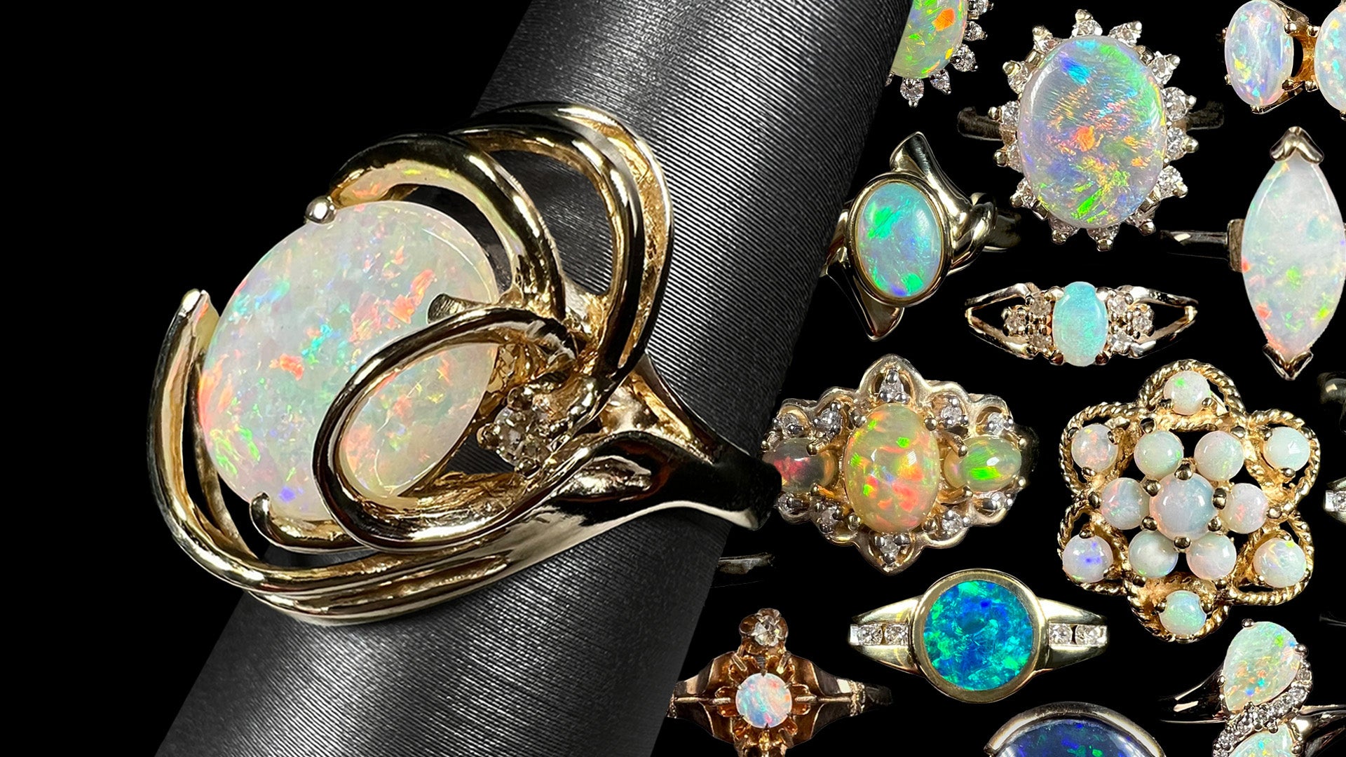 A yellow gold opal cocktail ring shown from angle on ring display in front of collage of colorful yellow gold opal rings of different karat purities.