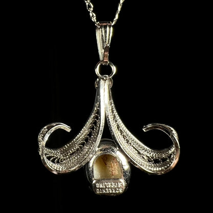 Back side of a Sorrento brand sterling silver opal pendant, shown against a black background.