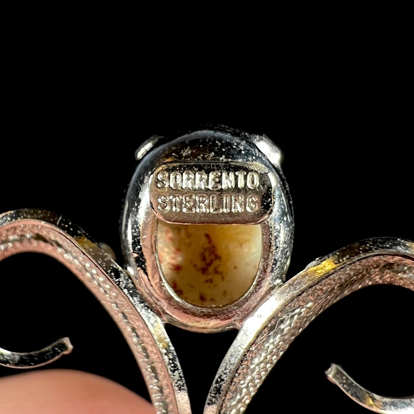 Back of a silver opal pendant showing the hallmarks, "SORRENTO" and "STERLING".