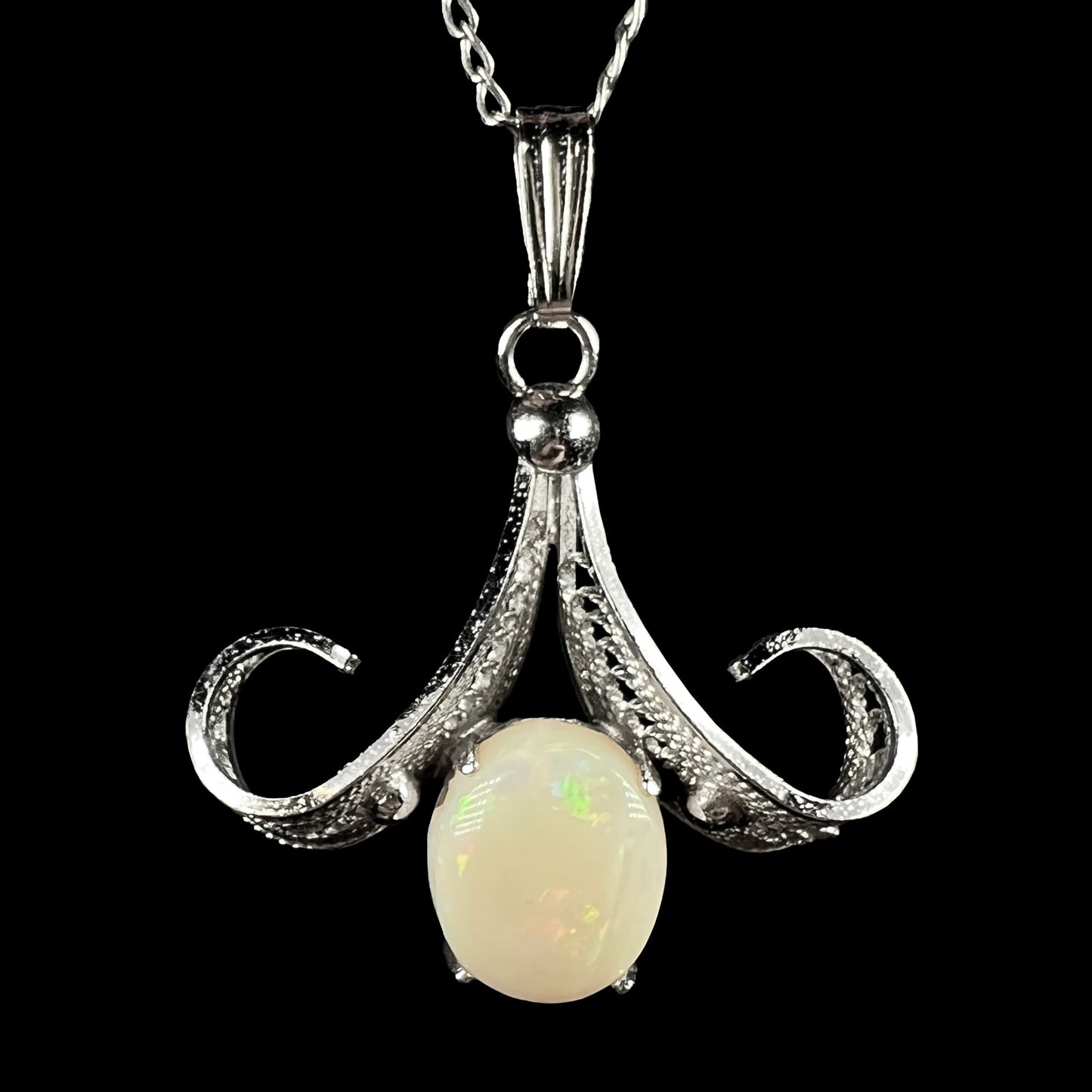 A Sorrento brand sterling silver Australian white opal pendant shown close-up against a black background.