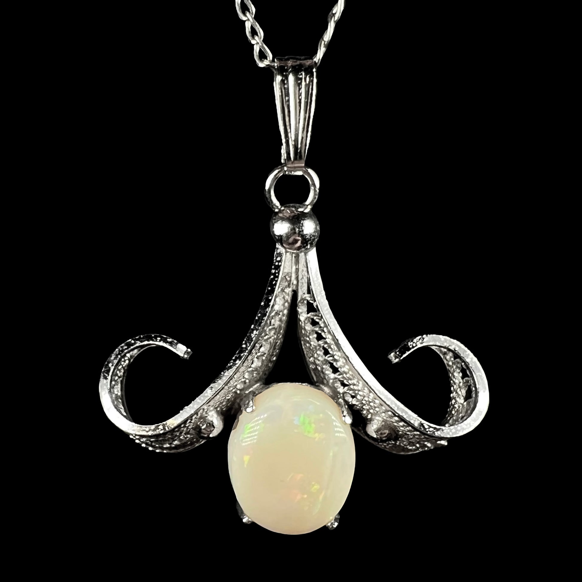 A Sorrento brand sterling silver Australian white opal pendant shown close-up against a black background.