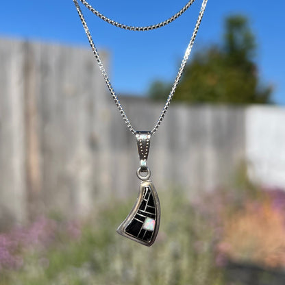 Southwest-style silver opal and onyx inlay necklace, viewed straight-on outside with natural light.