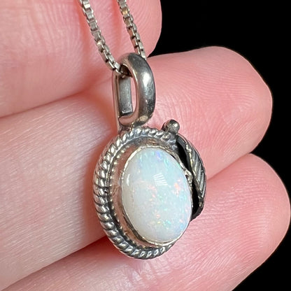 Angled side view of Southwest-inspired sterling silver opal pendant, held in hand
