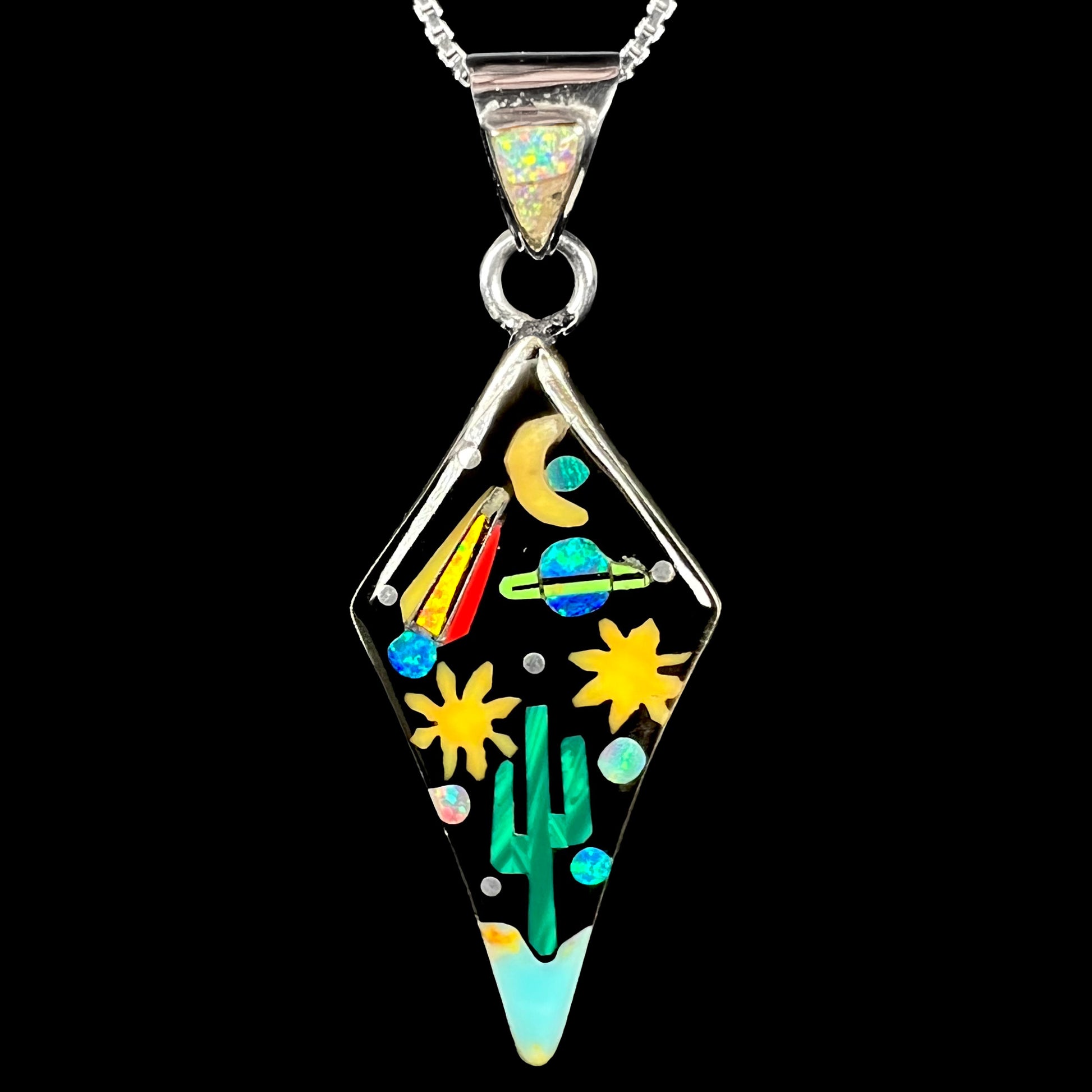 Southwest-style sterling silver opal, onyx, and malachite inlay pendant depicting motif of outer-space over desert floor, shown against black backdrop.
