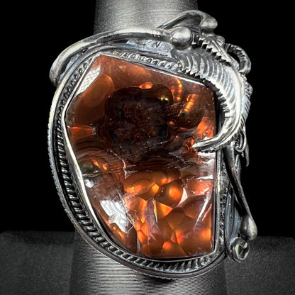 A men's silver, Southwest-style fire agate ring shown from the front view against a black background.