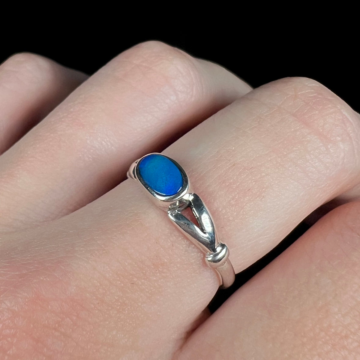 Silver opal doublet ring with split shank design, worn on finger