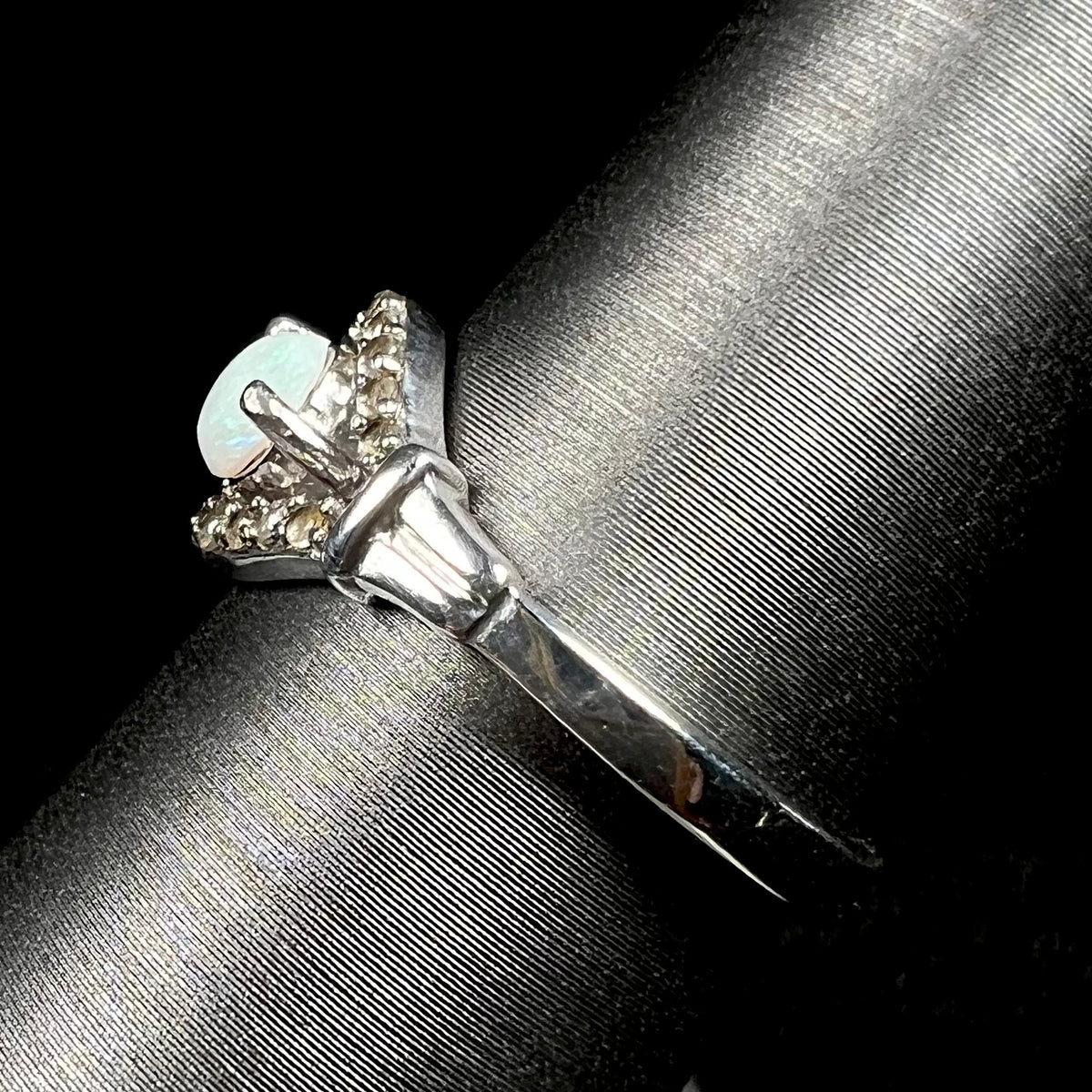 Side view of sterling silver Australian opal ring on ring display, focused on ring's polished shank