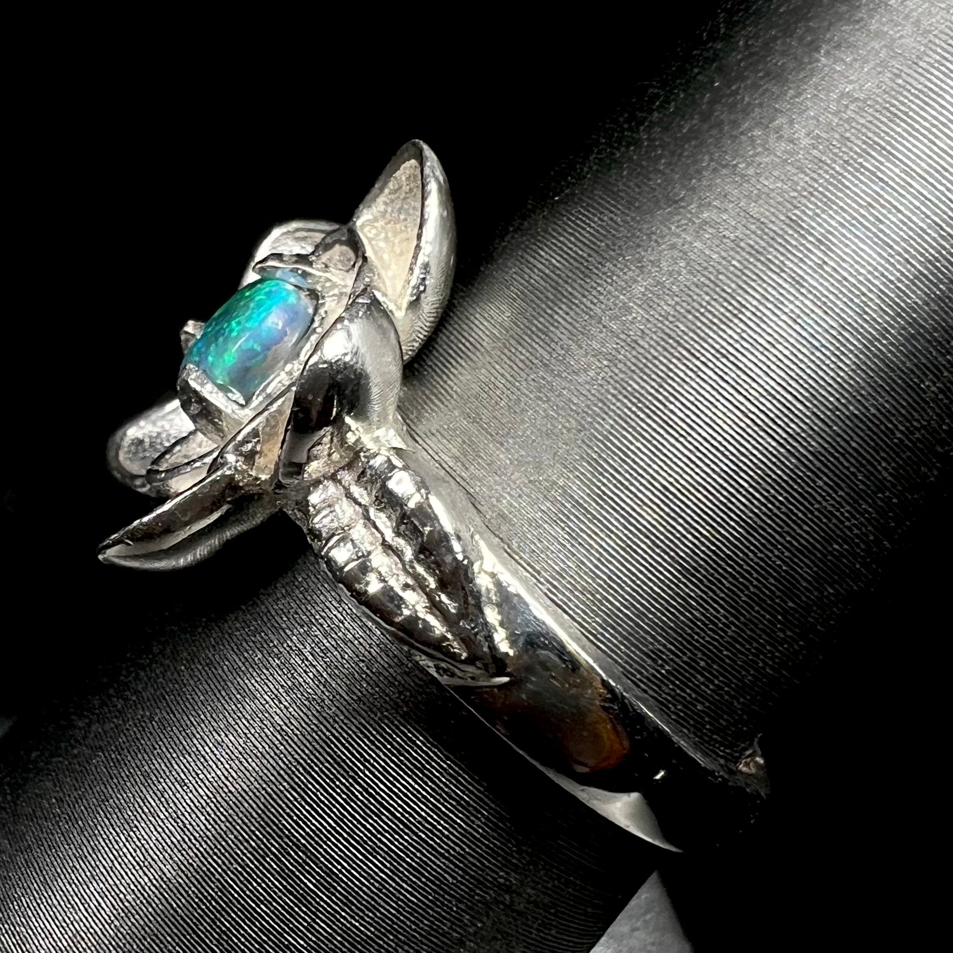 Side view of sterling silver lotus flower design ring set with solid Australian black opal