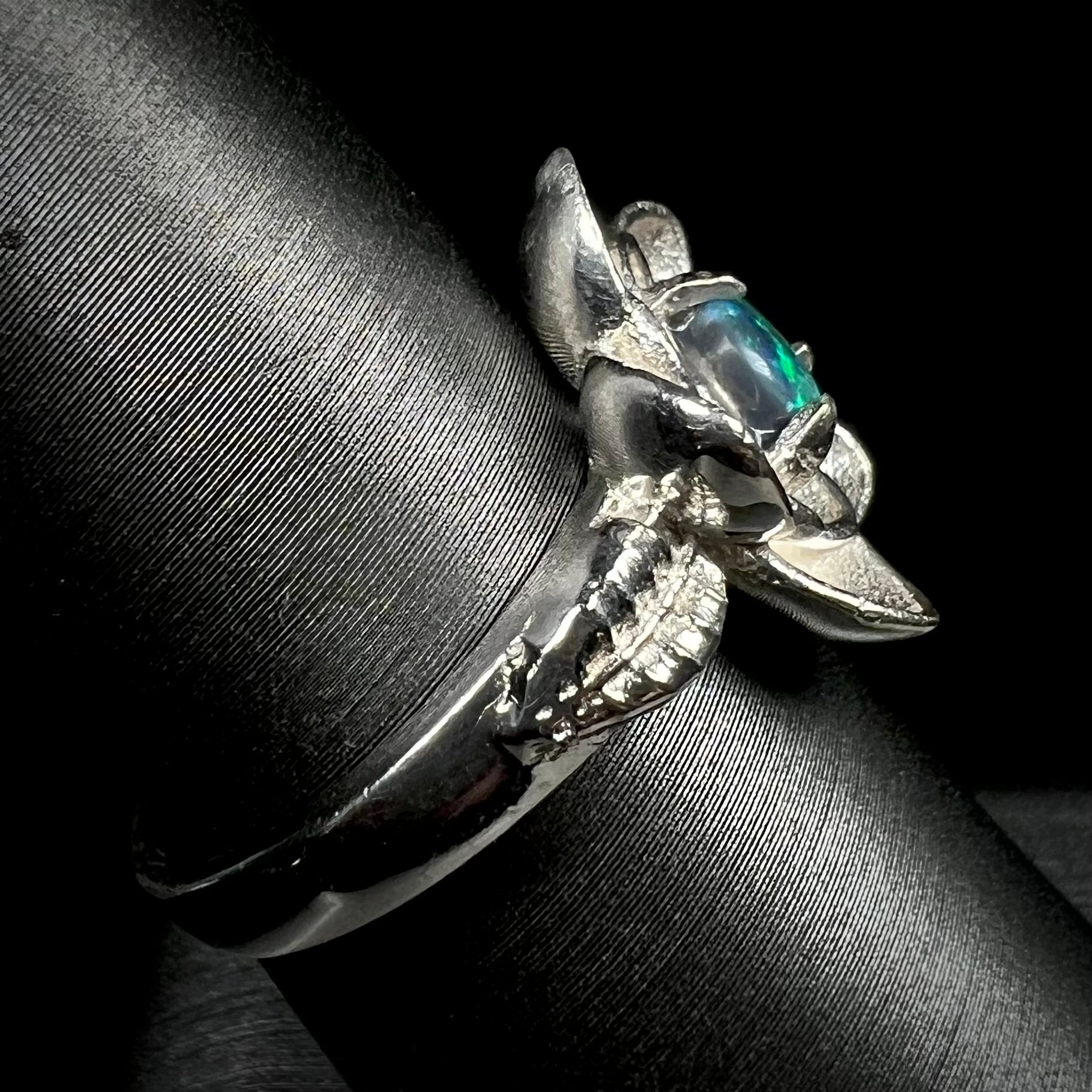 Sterling silver black opal women's ring with lotus flower design on ring display shown from side view