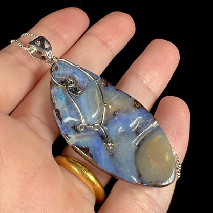 Close-up angled view of a large, blue Australian boulder opal necklace in sterling silver.
