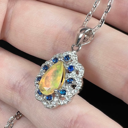 Sterling silver Ethiopian opal, CZ, and blue sapphire pendant shown close-up in hand