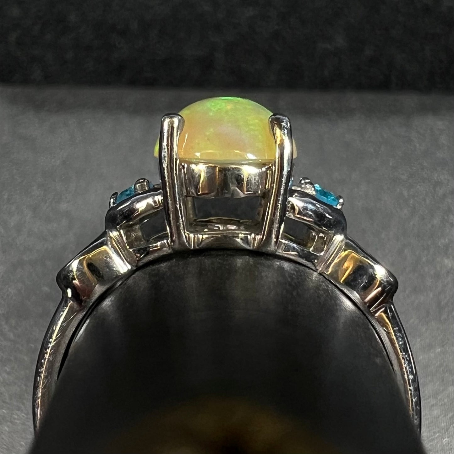 Side gallery profile view of sterling silver Ethiopian opal ring with blue apatite accents on ring display
