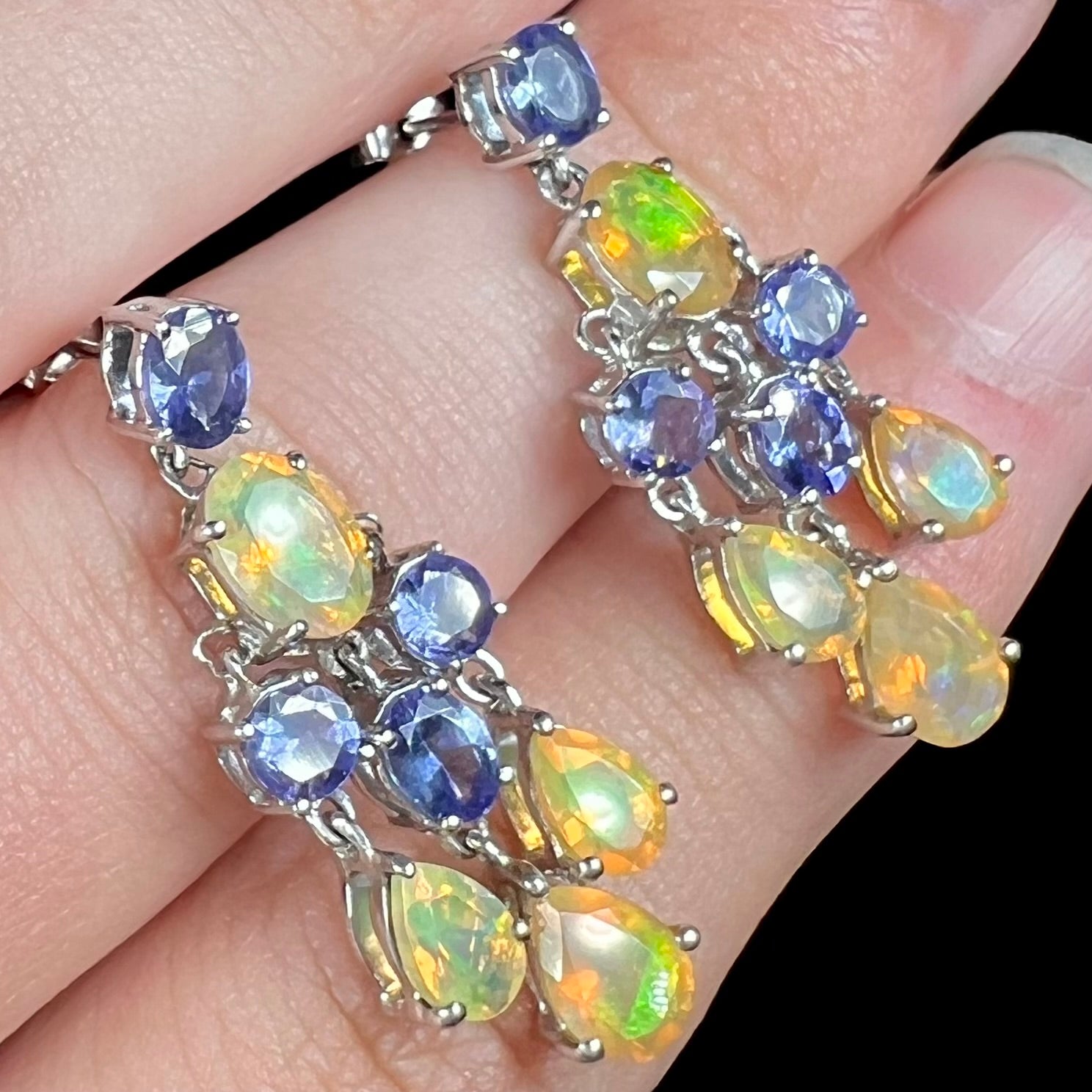 A pair of dangling sterling silver Ethiopian opal and tanzanite chandelier earrings.