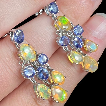 A pair of dangling sterling silver Ethiopian opal and tanzanite chandelier earrings.