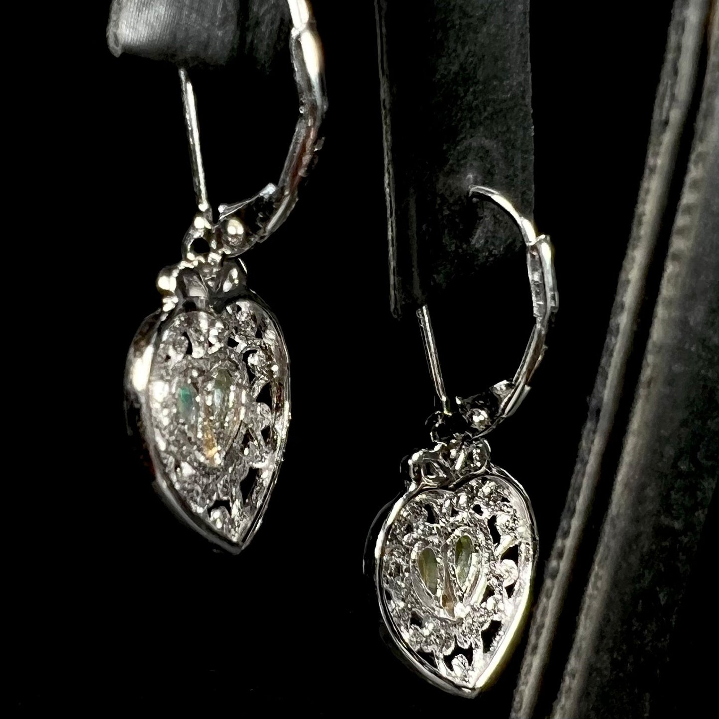 Back side of sterling silver filigree heart earrings set with opals.