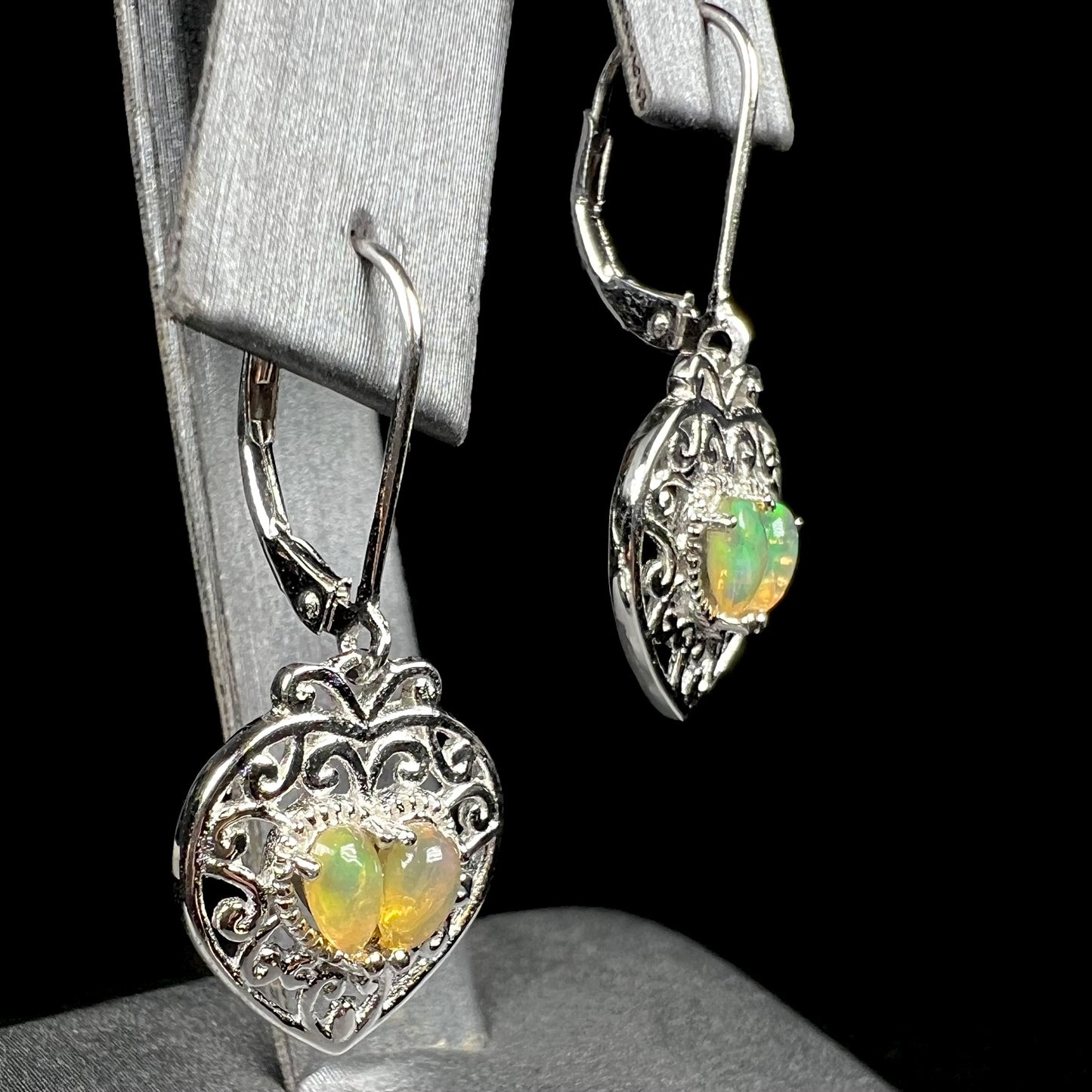 A pair of dangling sterling silver filigree heart earrings, each set with two Ethiopian opals.