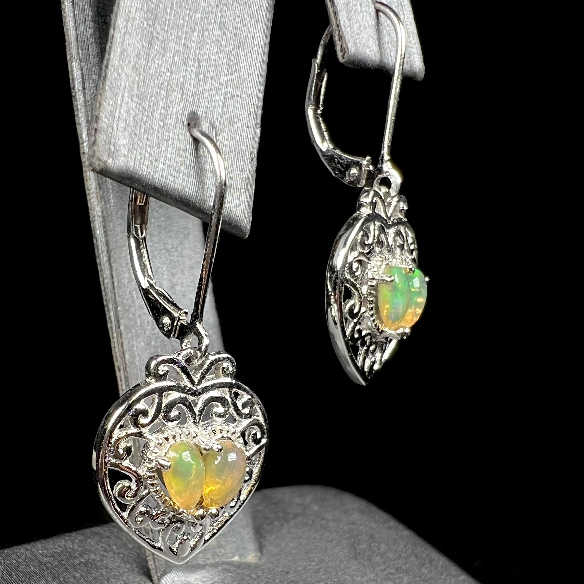 A pair of dangling sterling silver filigree heart earrings, each set with two Ethiopian opals.