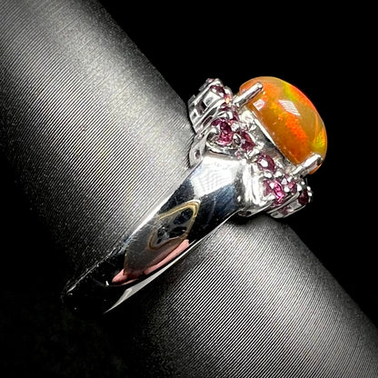 Sterling silver fire opal and garnet ring on display, viewed from side and focused on ring's shank