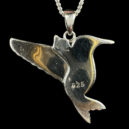 Back of a sterling silver hummingbird pendant on a silver chain, shown against a black background.