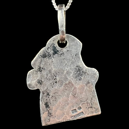 Back side of a sterling silver men's pendant showing the hallmark stamps, "925", "JG", and "STARBORN".