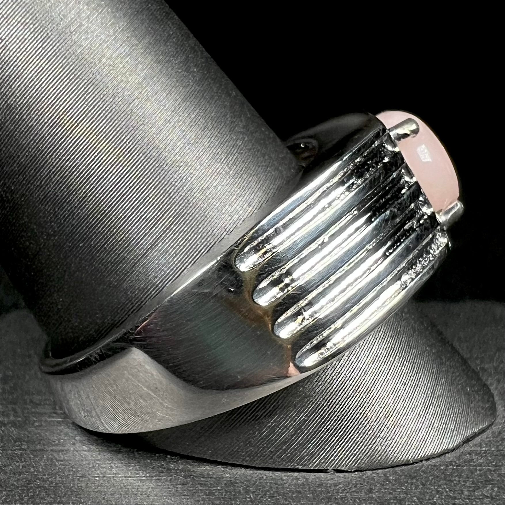 Side view of sterling silver men's ring set with pink Peruvian opal on ring display