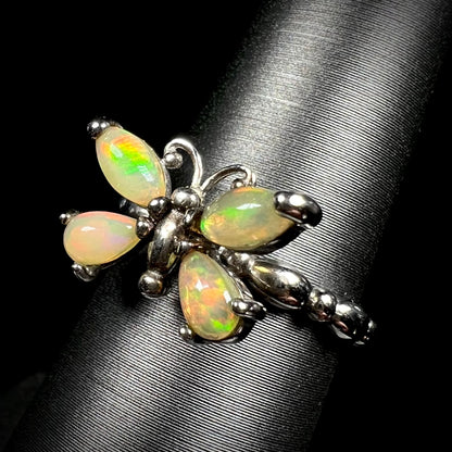 A sterling silver Ethiopian opal butterfly ring shown at an angle on a ring display against a black background.
