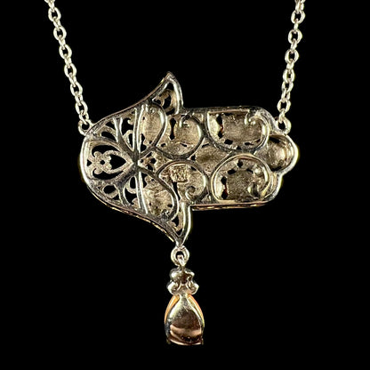 A sterling silver opal hamsa necklace, shown from the back.  No opals are visible.