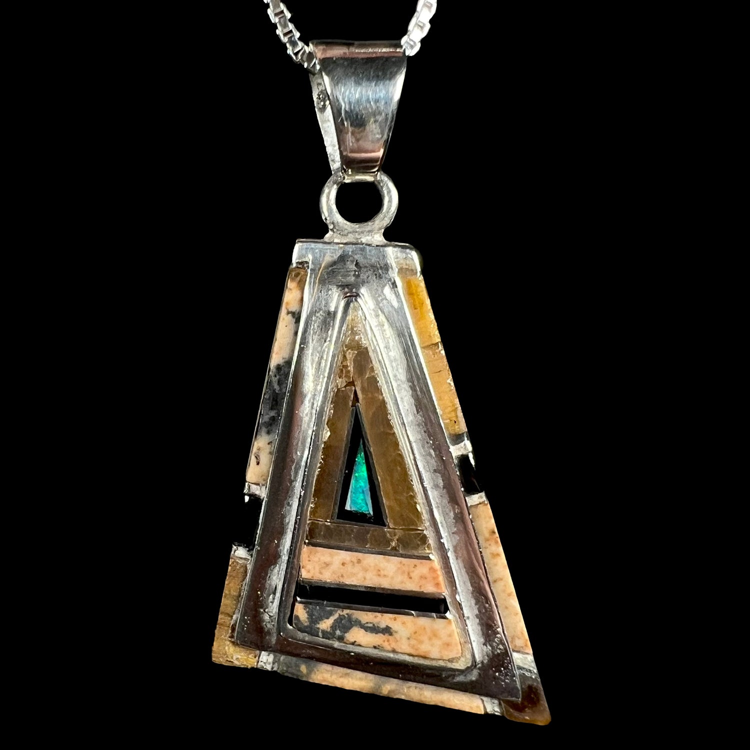 A sterling silver Australian opal, picture jasper, and onyx inlay pendant shown close-up against a black background.