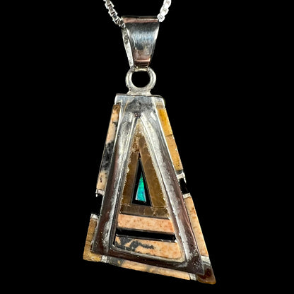 A sterling silver Australian opal, picture jasper, and onyx inlay pendant shown close-up against a black background.