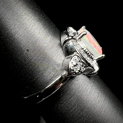 Side view of sterling silver Ethiopian opal ring on display, focused on ring's shank and CZ heart design