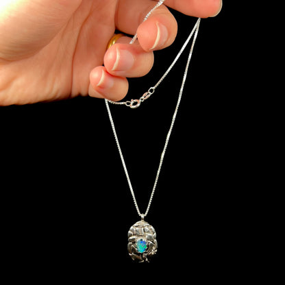 A unisex sterling silver pinecone-inspired opal triplet necklace.