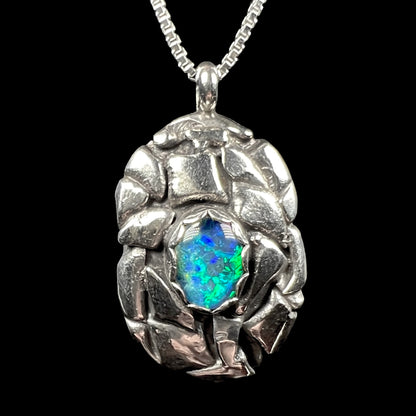 Front of a sterling silver pinecone-inspired opal triplet pendant, shown against a black background.
