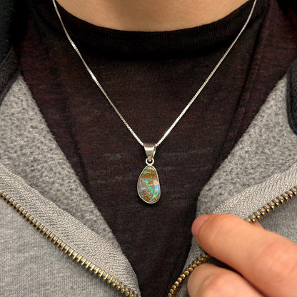 A sterling silver pendant set with an Australian boulder opal on a silver box chain.
