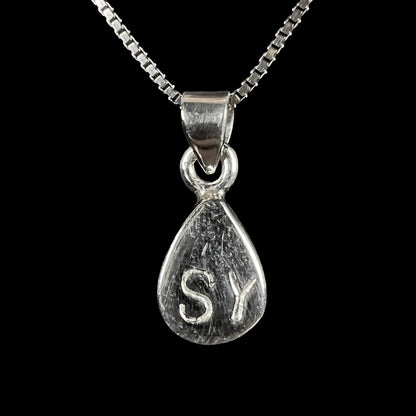 A dainty, sterling silver necklace bezel set with a natural, pear shaped opal stone.