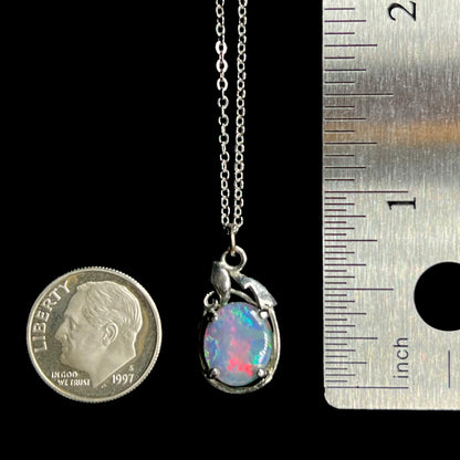 Base metal triplet opal pendant measuring 0.9 inch long, shown between US dime coin and ruler for scale