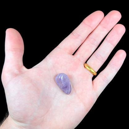 A tumble polished piece of speckled turkiyenite stone, also known as Turkish purple jade.