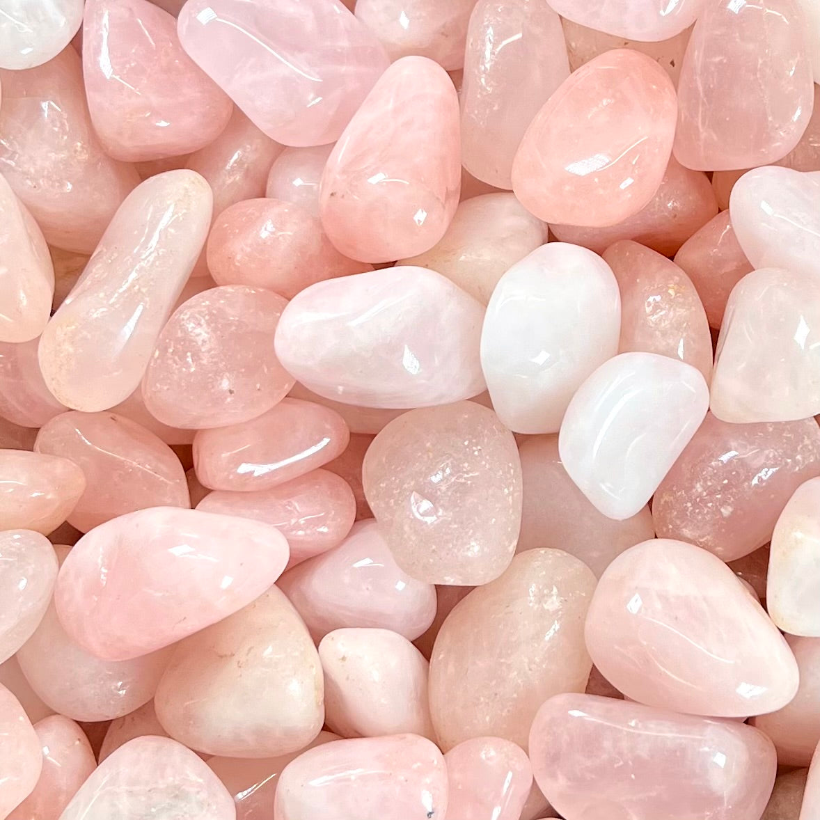 Pink, palm sized, tumble polished rose quartz stones.