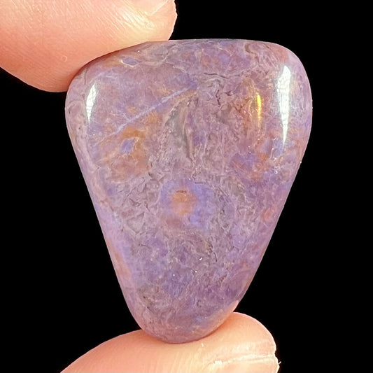 A tumbled turkiyenite stone, commonly referred to as "Turkish purple jade."