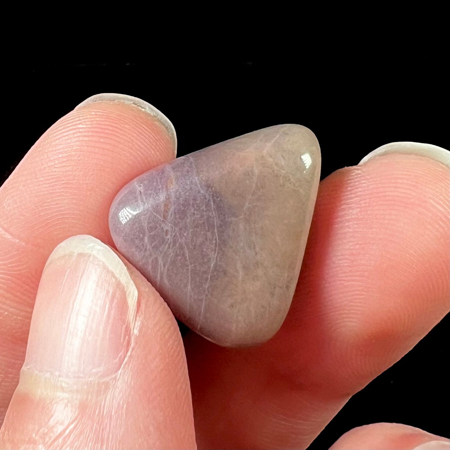 A tumble polished purple and brown turkiyenite jade stone from Bursa, Turkey.