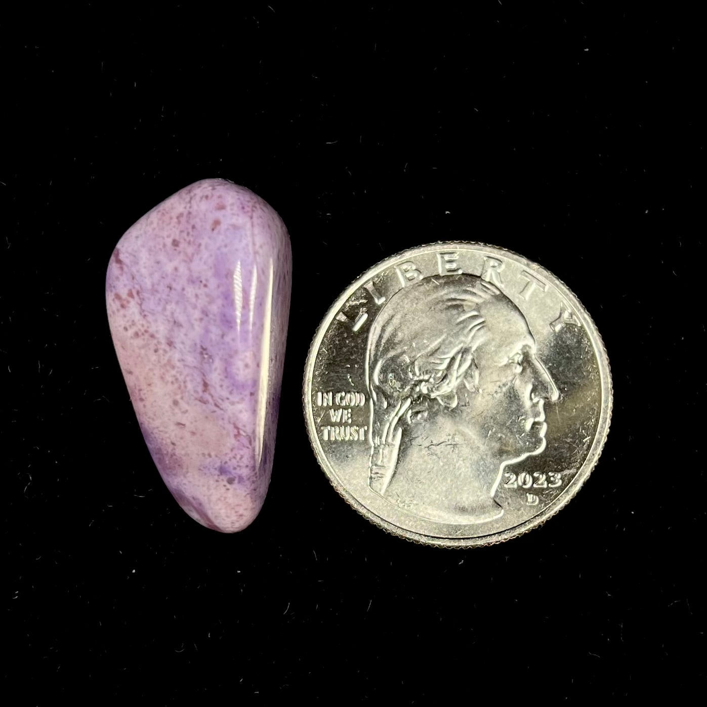 A tumble polished piece of speckled turkiyenite stone, also known as Turkish purple jade.