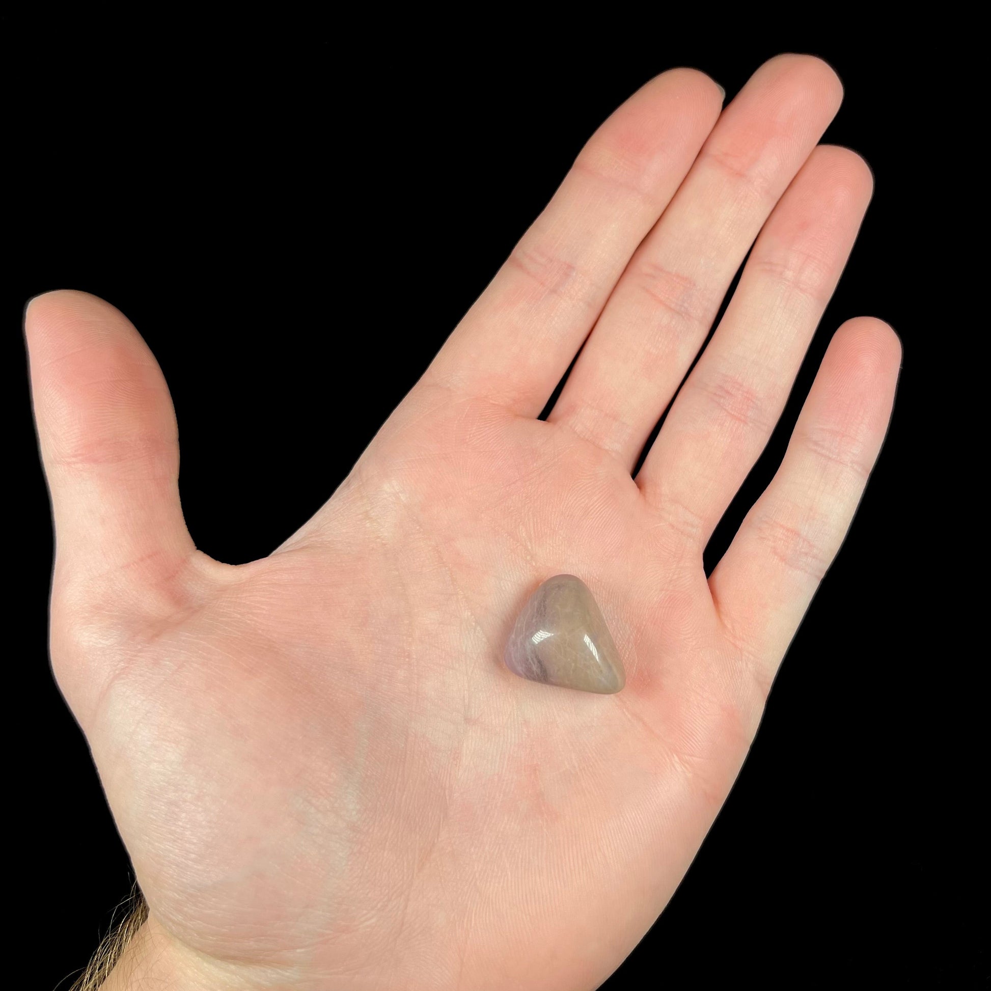 A tumble polished purple and brown turkiyenite jade stone from Bursa, Turkey.