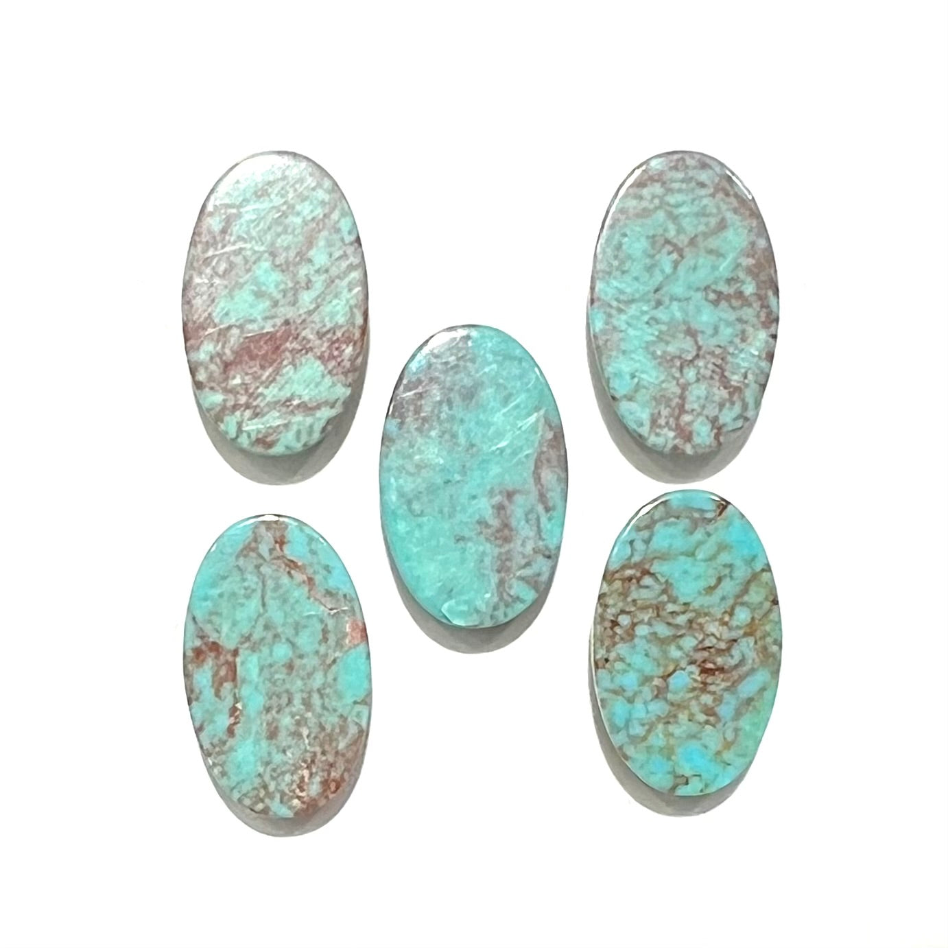 A loose lot of 5 oval cabochon cut Tyrone turquoise stones.  The stones are blue with red webbed matrix.