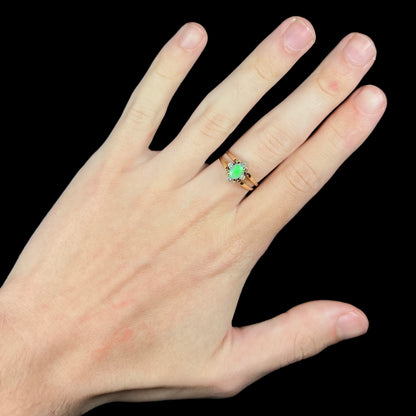 Hand wearing two-sided opal and diamond flip ring in 14k gold