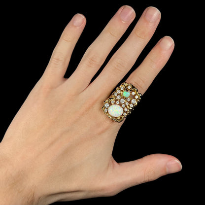 Hand wearing large two-stone lab-created opal and CZ statement ring on index finger.