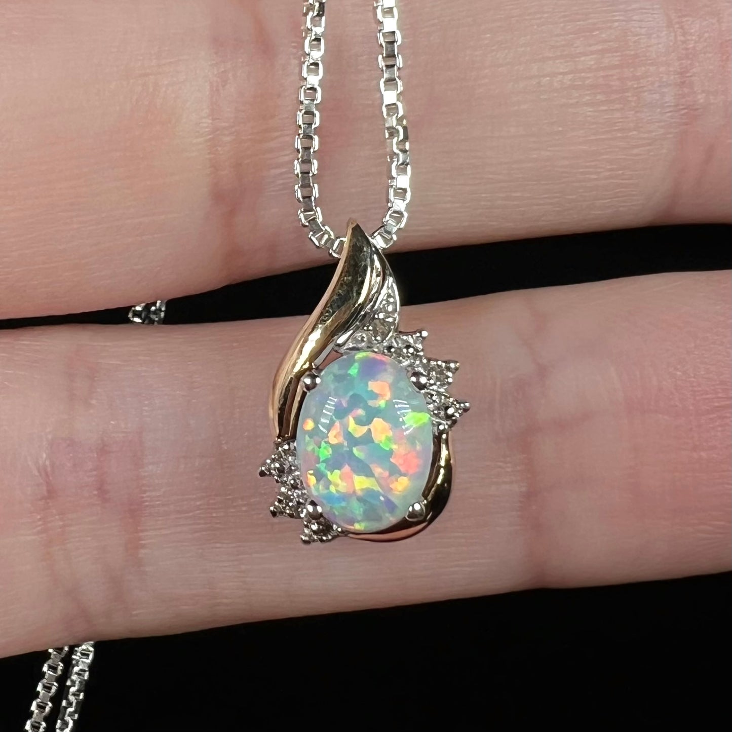 Close-up of a two-tone 10k gold-accented sterling silver opal and diamond pendant.