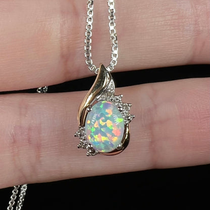 Close-up of a two-tone 10k gold-accented sterling silver opal and diamond pendant.