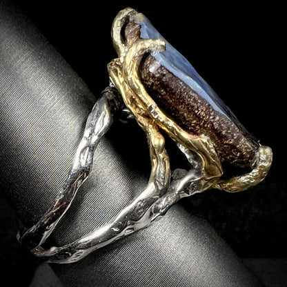 Side view of a two-tone boulder opal solitaire ring.  The shank is silver and the prongs are gold plated silver.
