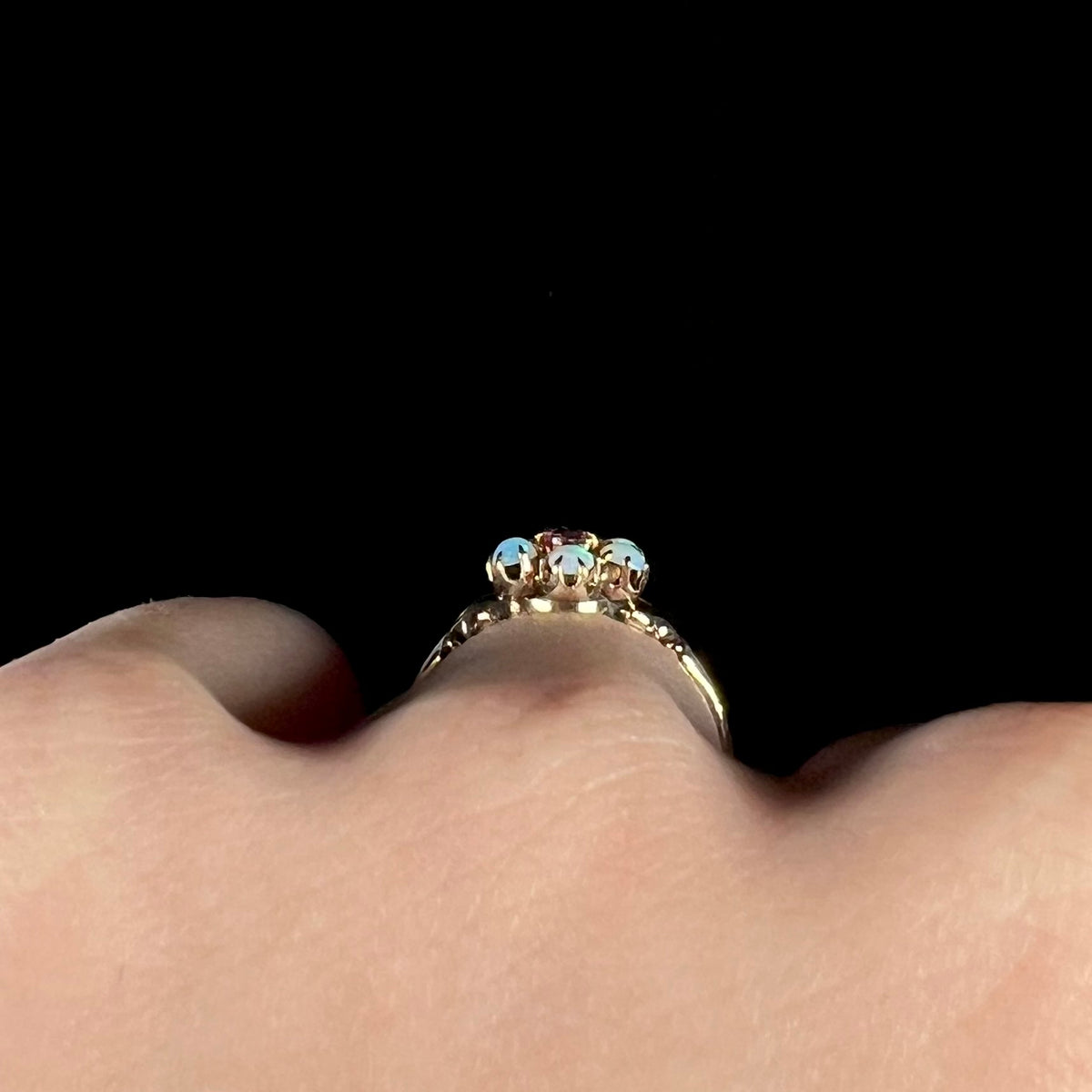 Side profile gallery view of a gold Victorian opal ring, worn on hand