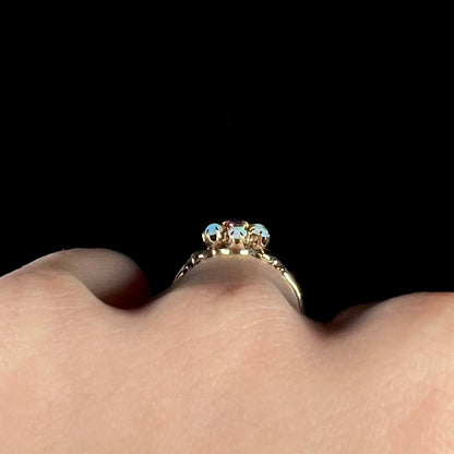 Side profile gallery view of a gold Victorian opal ring, worn on hand