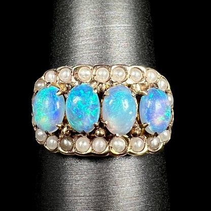 Close-up of Victorian four-stone opal and seed pearl halo ring in 9k gold, shown on ring display